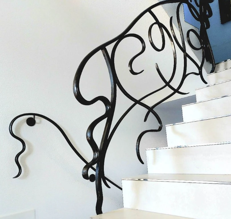 Escalier intérieur moderne avec garde-corps en fer forgé noir aux motifs floraux ornementaux