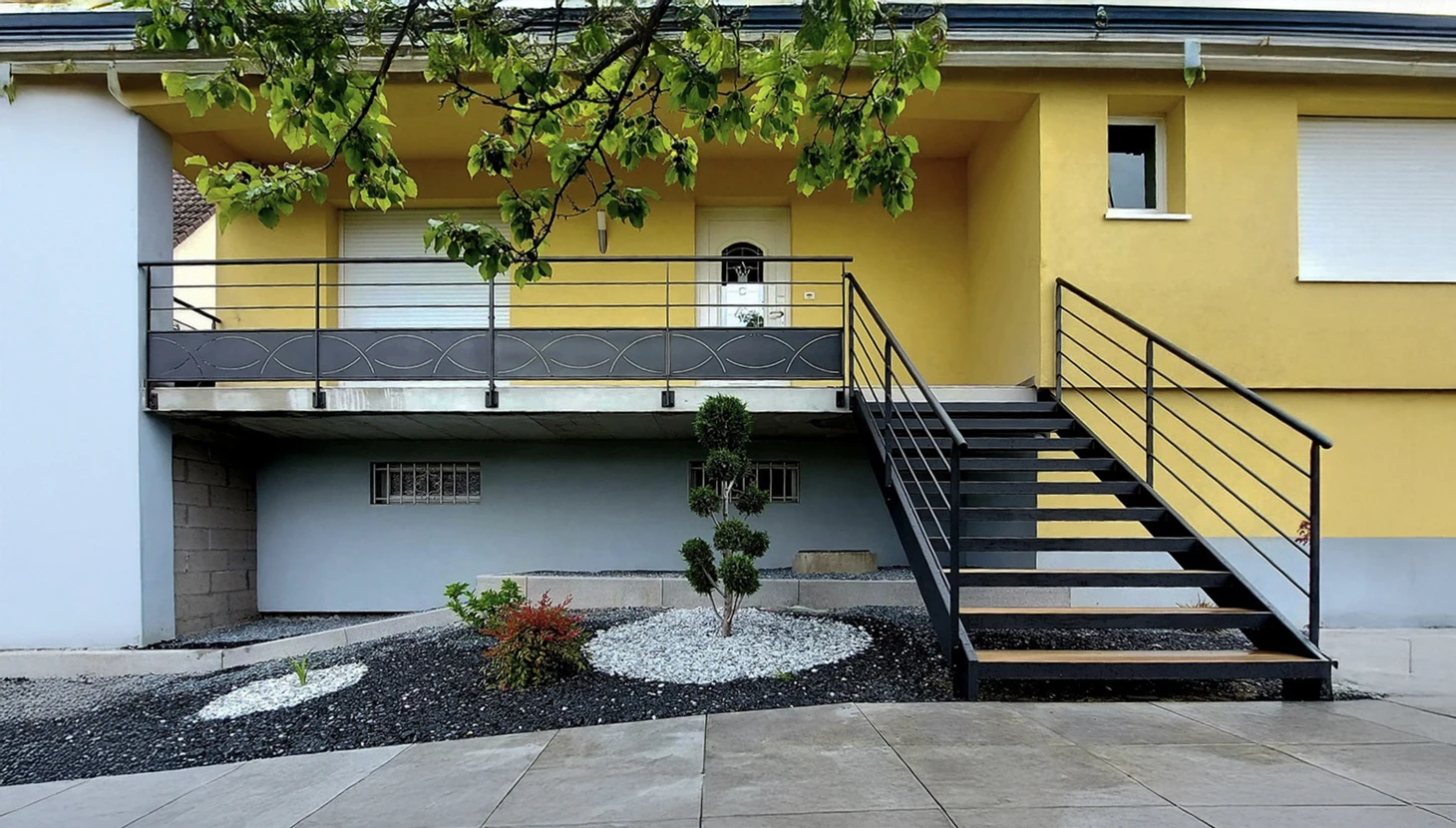 Escalier extérieur métallique moderne avec rampe horizontale menant à un balcon résidentiel