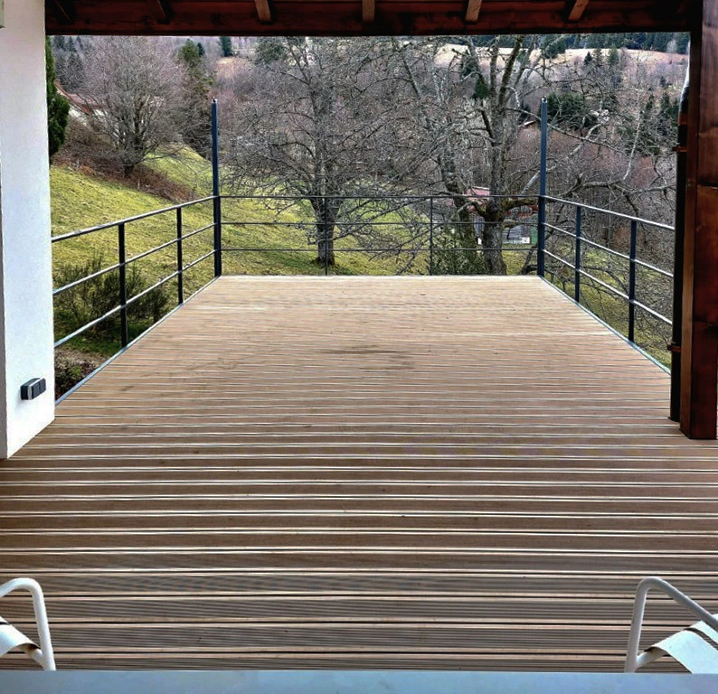 Terrasse extérieure en bois avec vue panoramique sur paysage vallonné