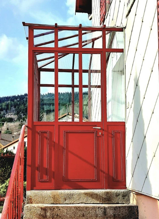 Portail en fer forgé blanc artistique avec motifs végétaux ondulants, installé entre piliers maçonnés