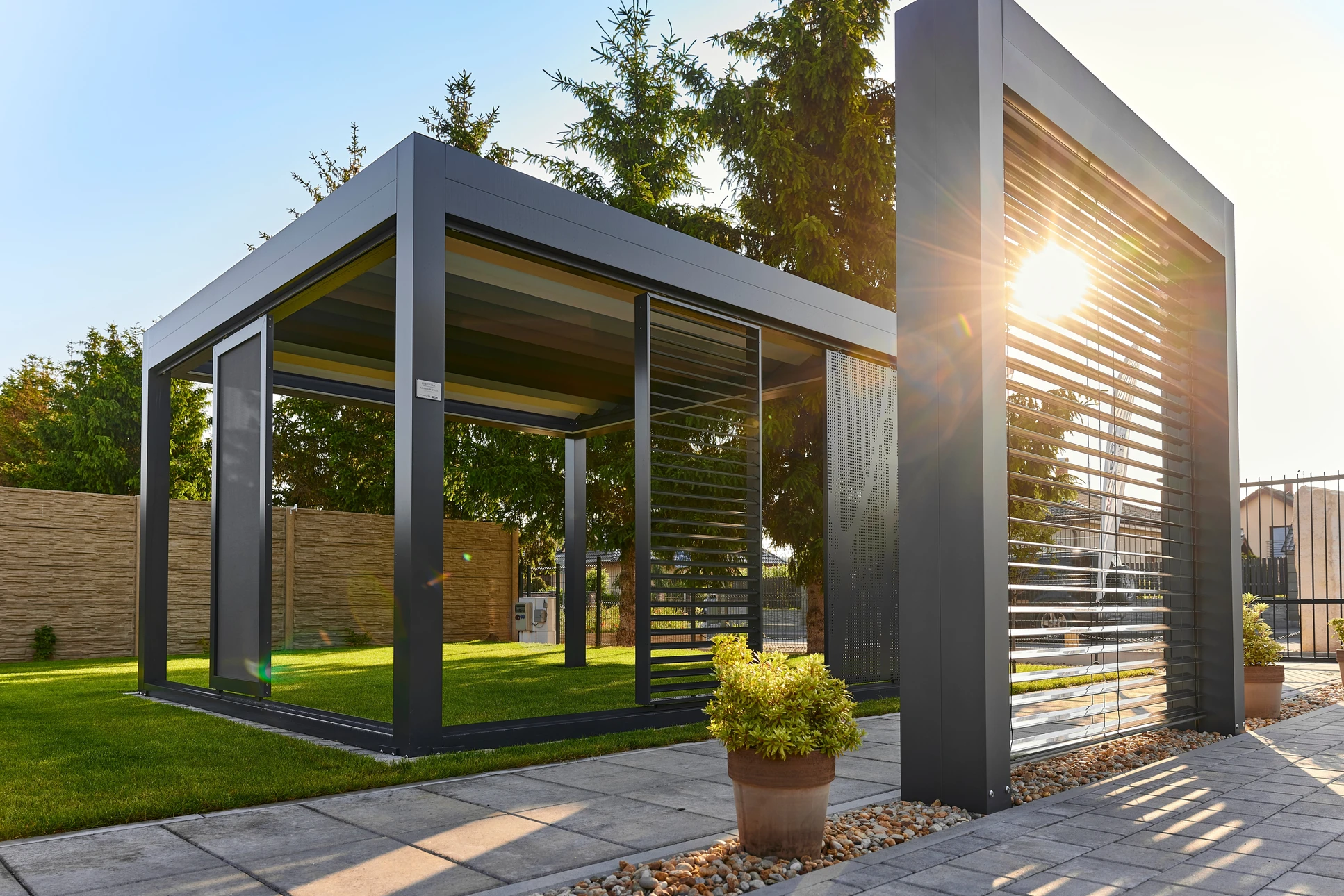 Terrasse extérieure moderne avec deux fauteuils coques en résine tressée beige disposés sur deck en bois exotique