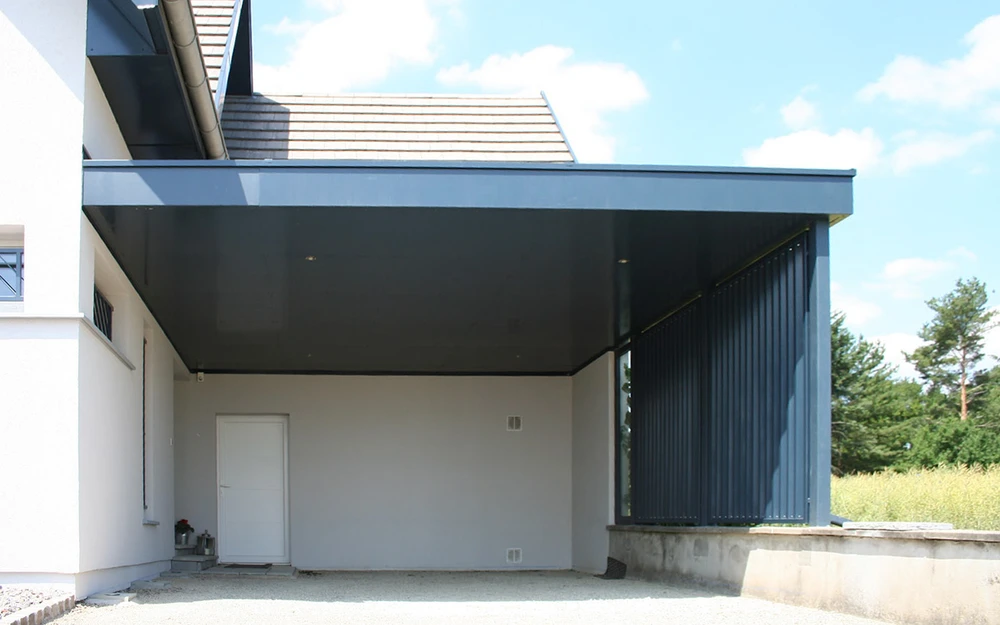 Portail en fer forgé blanc artistique avec motifs végétaux ondulants, installé entre piliers maçonnés