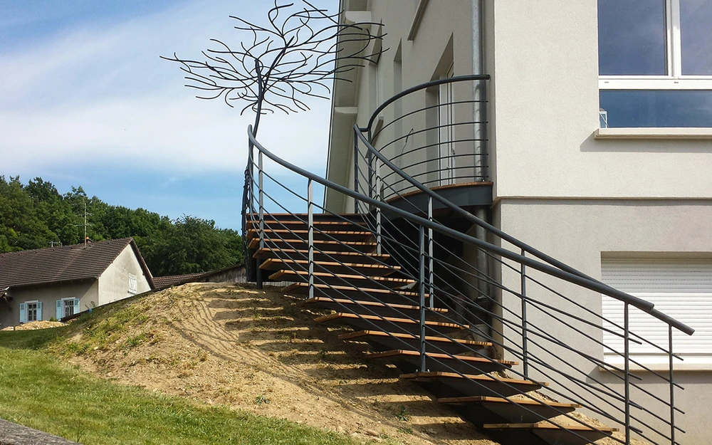 Escalier intérieur moderne avec garde-corps en fer forgé noir aux motifs floraux ornementaux