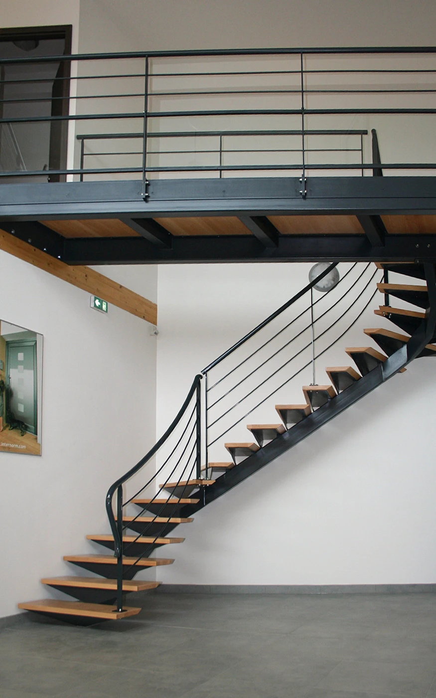 Portail en fer forgé blanc artistique avec motifs végétaux ondulants, installé entre piliers maçonnés