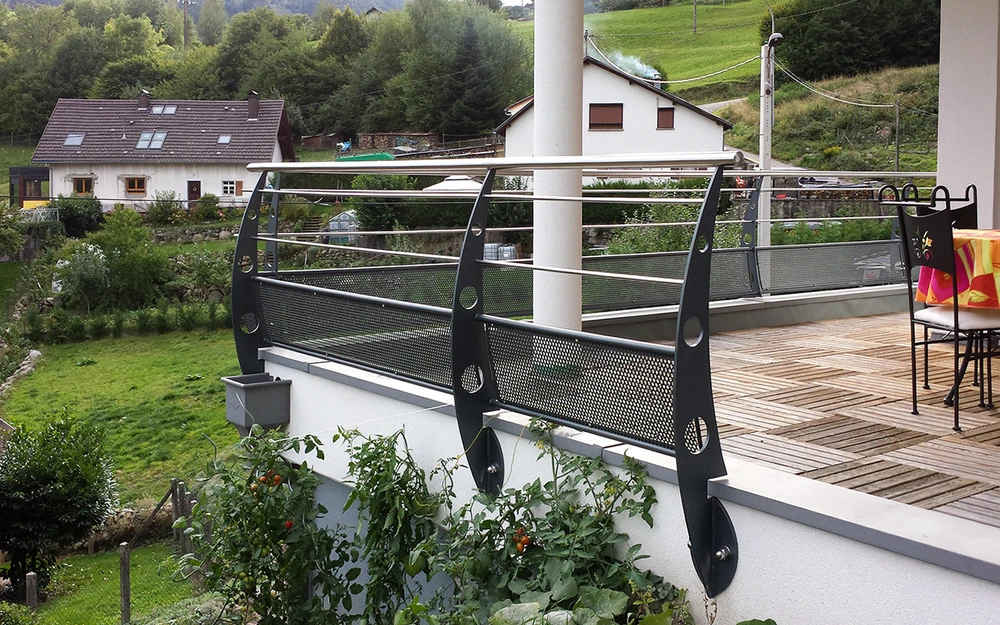 Portail en fer forgé blanc artistique avec motifs végétaux ondulants, installé entre piliers maçonnés
