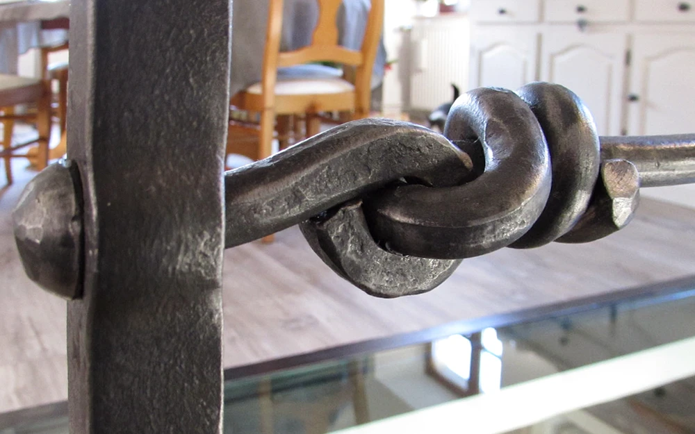 Portail en fer forgé blanc artistique avec motifs végétaux ondulants, installé entre piliers maçonnés